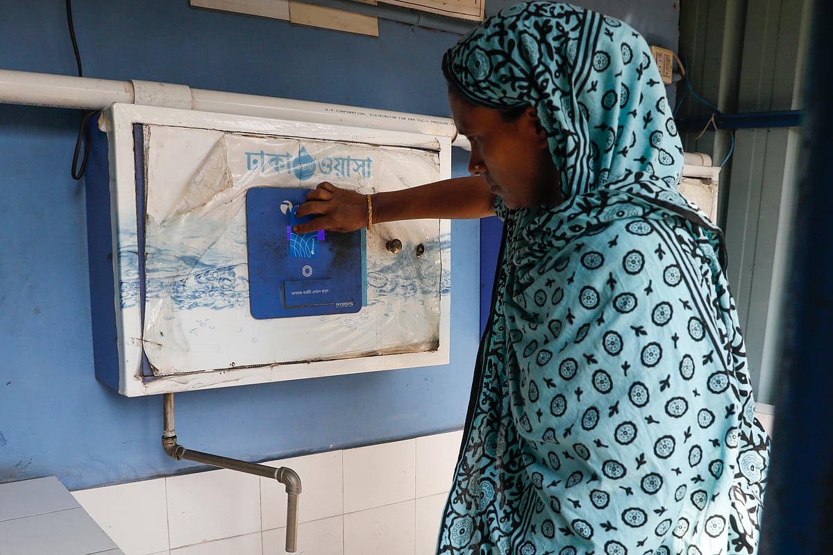 বিশুদ্ধ পানি পাওয়ার জন্য প্রি-পেইড কার্ড ব্যবহার করছেন এক নারী। শনির আখড়া, ঢাকা