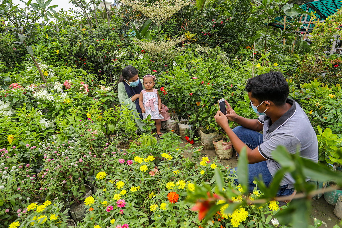 ছোট্ট মেয়েকে সঙ্গে নিয়ে জবা ফুলের গাছ কিনতে এসেছেন নার্সারিতে