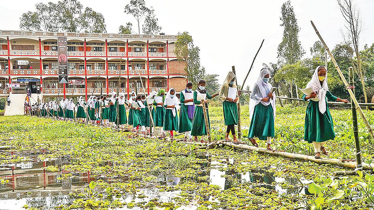 বানের পানি পেরিয়েই শিশুরা অনেক জায়গায় স্কুলে যেতে শুরু করেছে