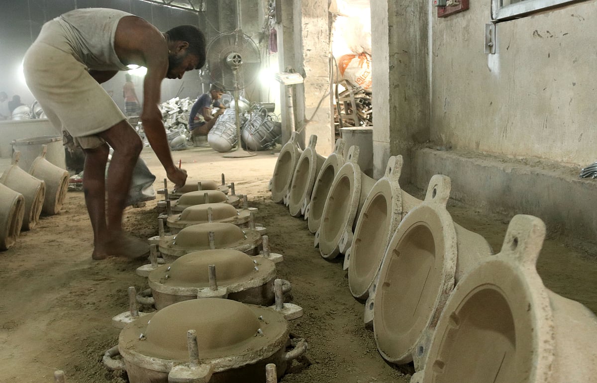 কড়াই তৈরির ছাঁচ বানাচ্ছেন এক শ্রমিক