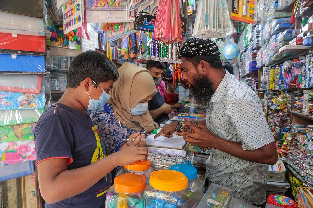 বাংলাবাজারে সন্তানকে নিয়ে খাতা-কলম কিনছেন এক অভিভাবক।