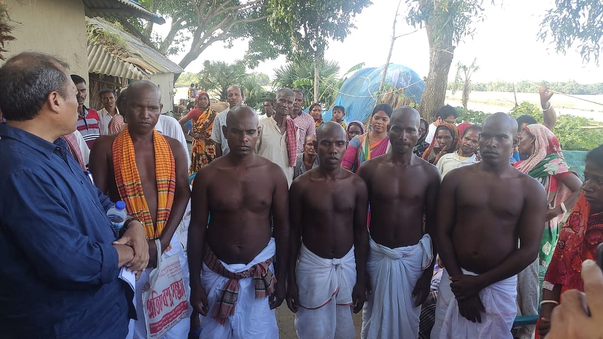 নরেন্দ্রনাথের পাঁচ সন্তান মুন্ডাদের সামাজিক-ধর্মীয় রীতি অনুযায়ী সাদা থান ধুতি পরে, খালি গায়ে রাস্তায় দাঁড়িয়ে আছেন ‘দশাকামা’ আয়োজনের জন্য