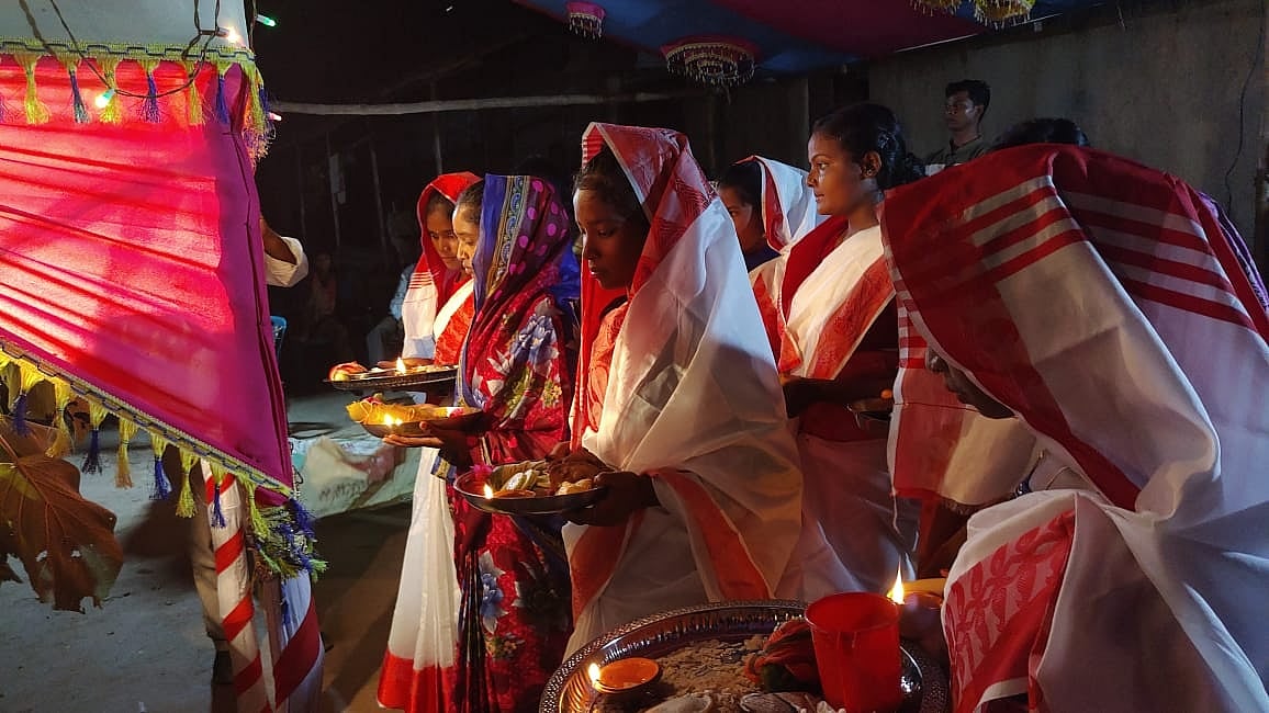 কারাম ডালের পূজা দেওয়ার জন্য কাঁসার থালায় ফুল-ফল, তেলের পিঠা, ধূপ-ধুনো সাজিয়ে বেদির সামনে গ্রামের অবিবাহিত মেয়েরা