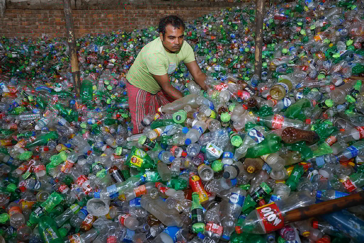 প্লাস্টিকের বোতল স্তূপ করছেন এক শ্রমিক