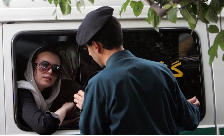 হিজাব পরা নিয়ে এক নারীকে জিজ্ঞাসাবাদ করছে ইরানের পুলিশ কর্মকর্তা। ছবি: এএফপি