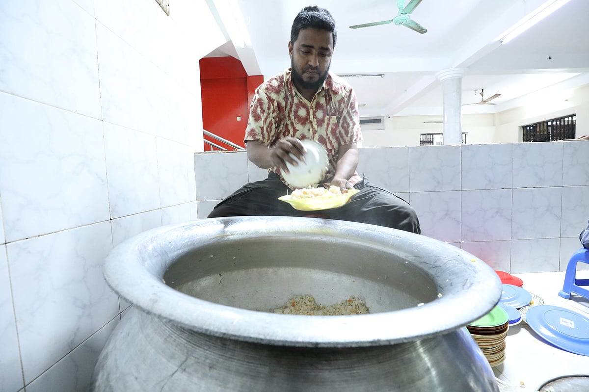 থালায় ইফতারি দিচ্ছেন স্বেচ্ছাসেবক।
 