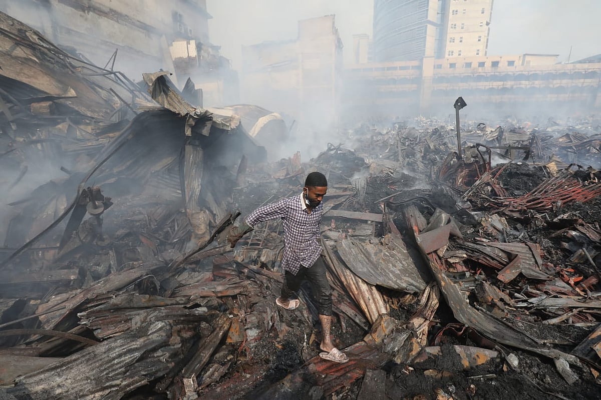 ধ্বংসস্তূপের মধ্যে দিয়ে হাঁটছেন একজন।