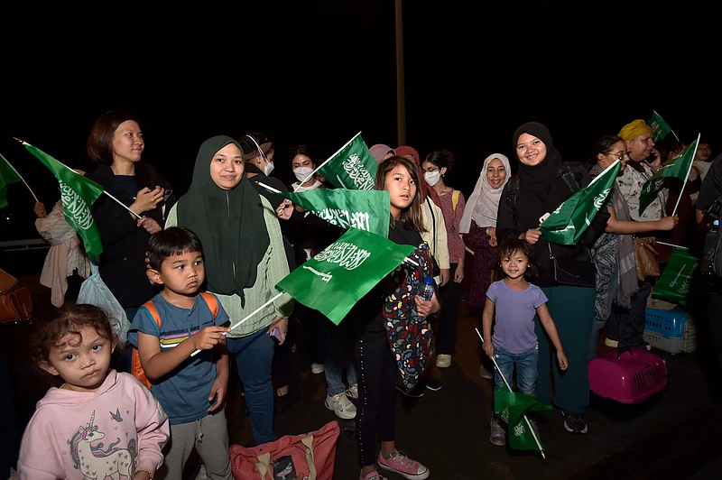 সুদান থেকে জেদ্দার কিং ফয়সাল নৌঘাঁটিতে পৌঁছানোর পর মানুষ সৌদির জাতীয় পতাকা উত্তোলন করছেন