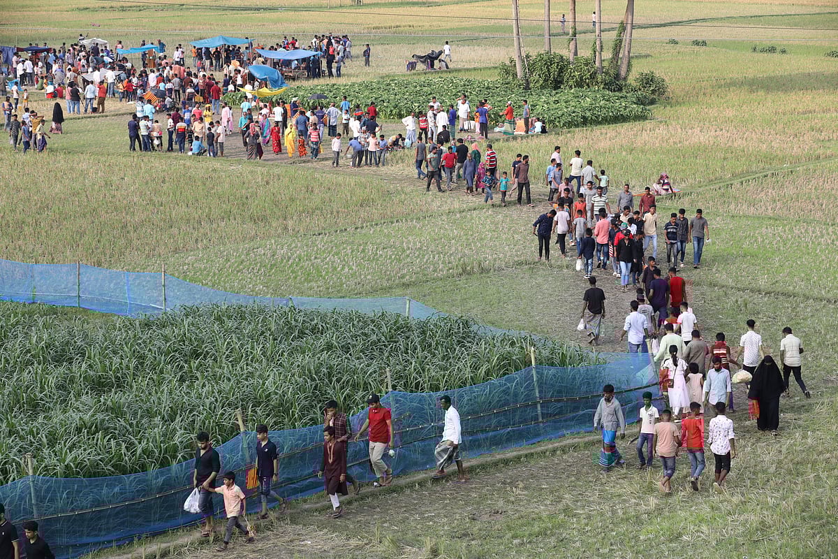 গ্রামের মাঠ পেরিয়ে মেলায় আসছে অনেক মানুষ।  