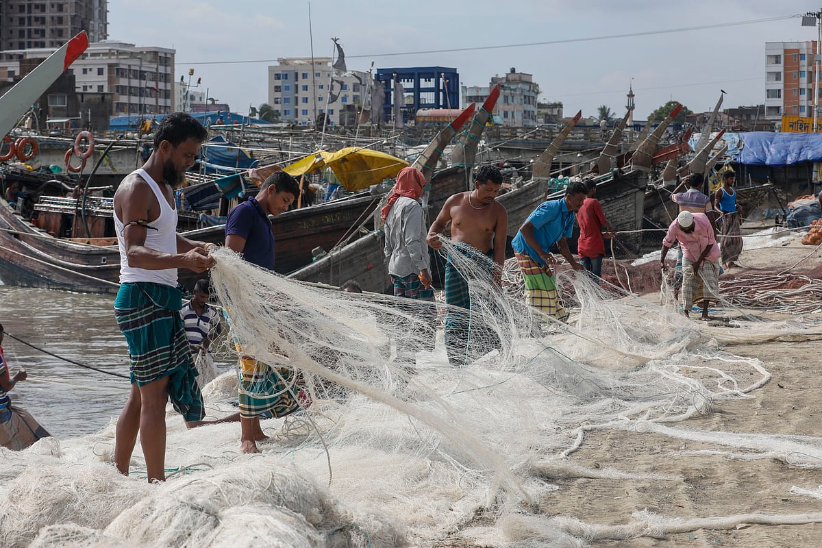 নৌকায় জাল তোলার আগে শেষবারের মতো দেখে নিচ্ছেন জেলেরা