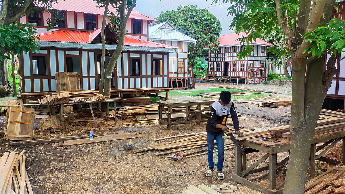 ঘর তৈরির জন্য কাঠের তক্তা কাটছেন এক মিস্ত্রি।
 