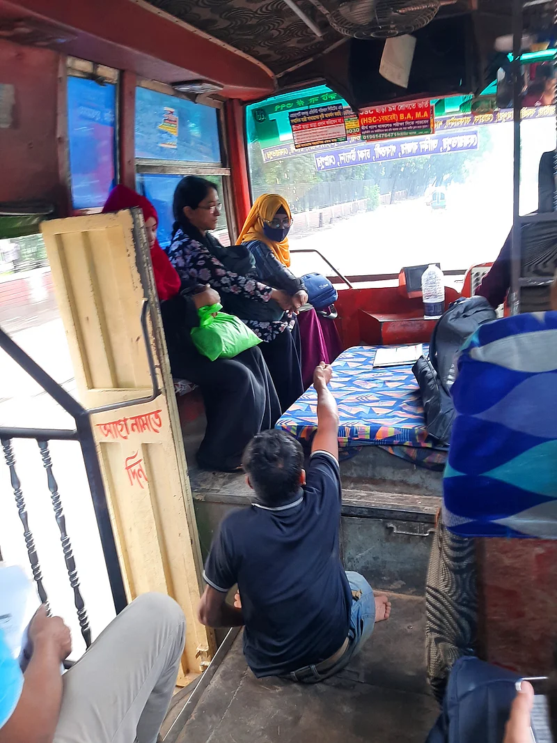 দুই হাতে ভর দিয়ে বাসযাত্রীদের কাছ থেকে ভাড়া নেন নূর আলম