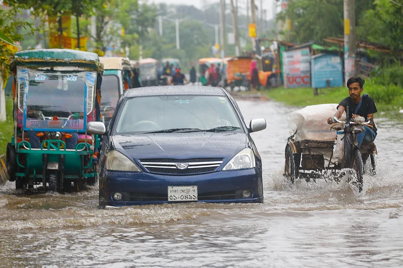 জলাবদ্ধ সড়কে পানির মধ্য দিয়ে চলছে যানবাহন।