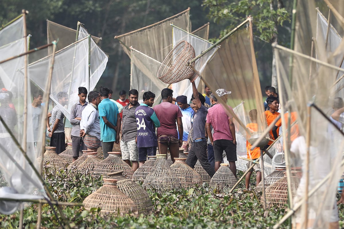 বিলে নামার আগে পলো ও জাল নিয়ে অপেক্ষায় লোকজন