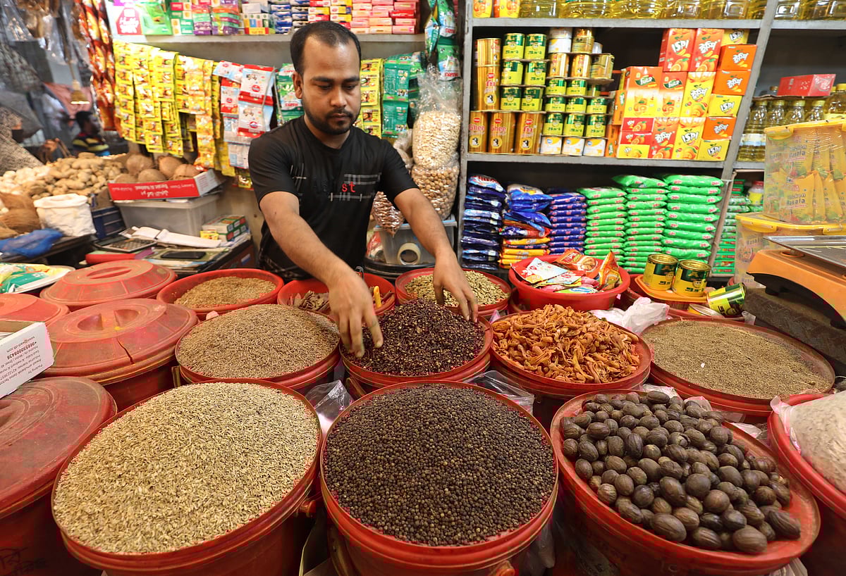 পাত্রে মসলা সাজিয়ে রেখেছেন এক দোকানি। সব পাত্র মসলায় পূর্ণ। 
