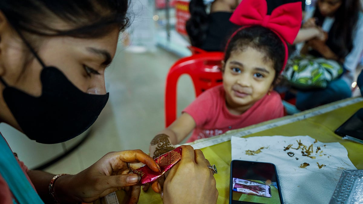 হাতে মেহেদি দিতে পেরে খুশি এই শিশু