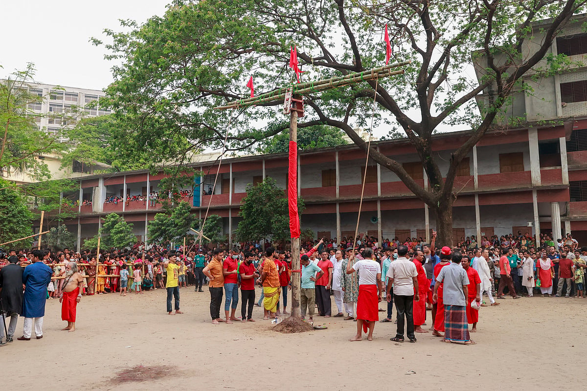 মাঠের মাঝখানে চড়কগাছ (গুঁড়ি) স্থাপন করছেন ভক্তরা। এই গুঁড়ি ঘিরেই ঝুলবেন শিবের বেশে একজন