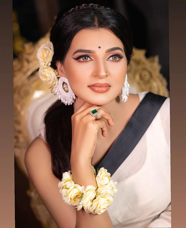 হাতের সবুজ পাথরের আংটি নজর কাড়ছে। সঙ্গে কালারড লেন্স পরেছেন বর্ষা। হাতে আর চুলে সাদা গোলাপের মালা। 