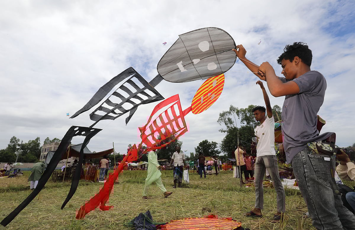 মেলায় মানুষের আকৃতির ঘুড়ি দেখাচ্ছেন বিক্রেতা। 