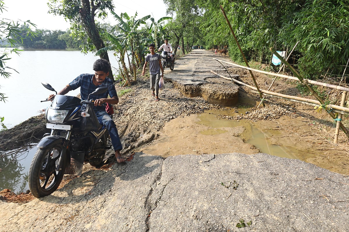পানির তোড়ে ভেঙে গেছে গ্রামের রাস্তা। সেই পথেই মোটরসাইকেল চালিয়ে যাচ্ছেন এক চালক। 