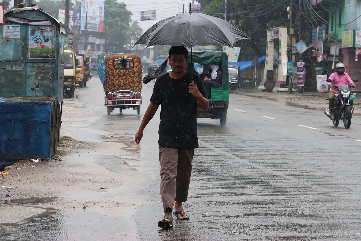 ছাতা মাথায় হেঁটে গন্তব্যের দিকে এক ব্যক্তি। 