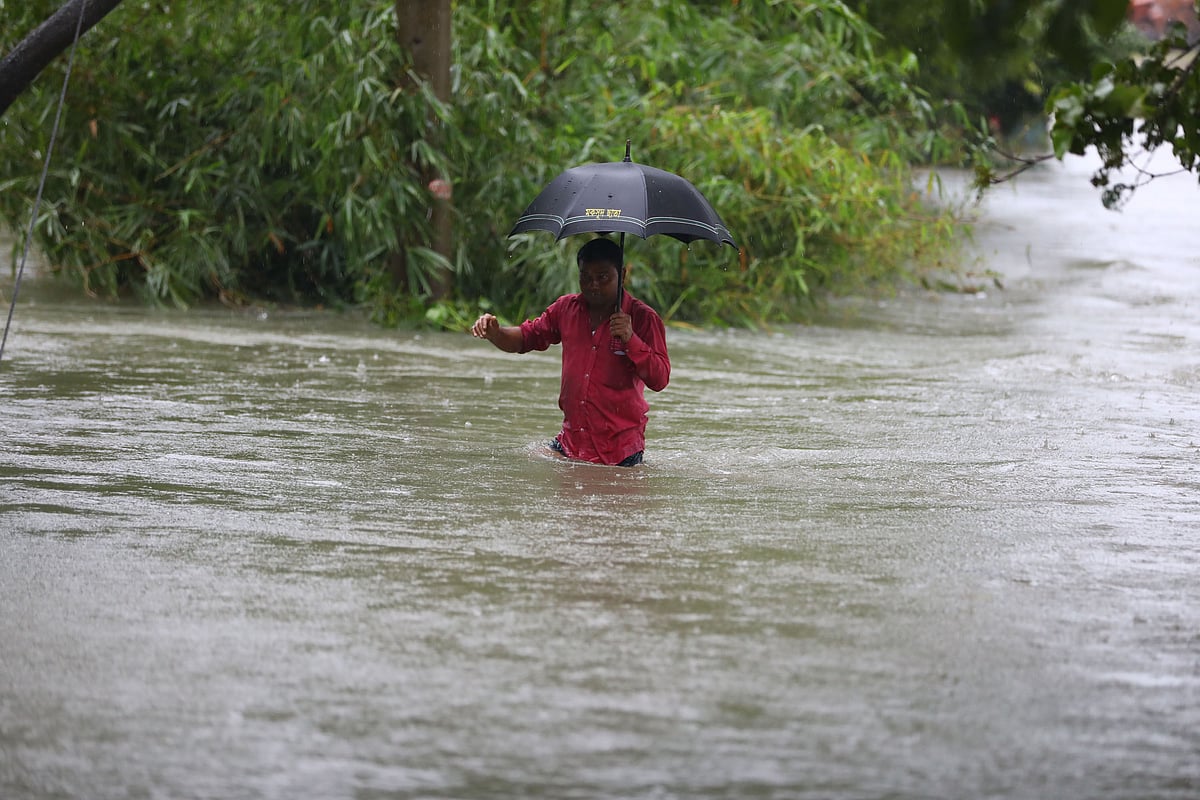কোমরসমান পানি মাড়িয়ে চলেছেন একজন। গোয়াইনঘাট উপজেলার রানীগঞ্জ গ্রামে।