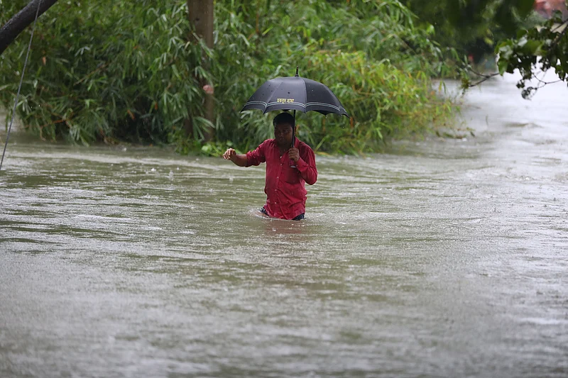 কোমরসমান পানি মাড়িয়ে চলেছেন একজন। গোয়াইনঘাট উপজেলার রানীগঞ্জ গ্রামে।
