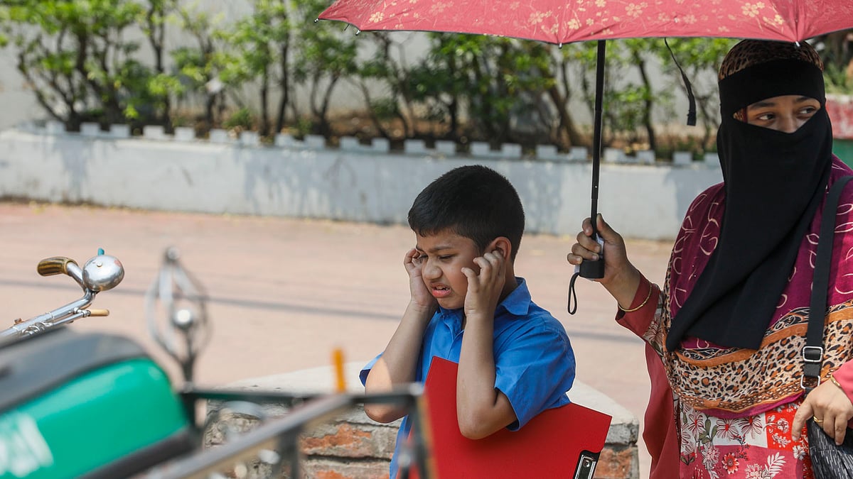 সড়ক পার হওয়ার সময় গাড়ির হর্নের শব্দ সহ্য করতে না পেরে হাত দিয়ে কান ঢেকে রেখেছে শিশুটি।