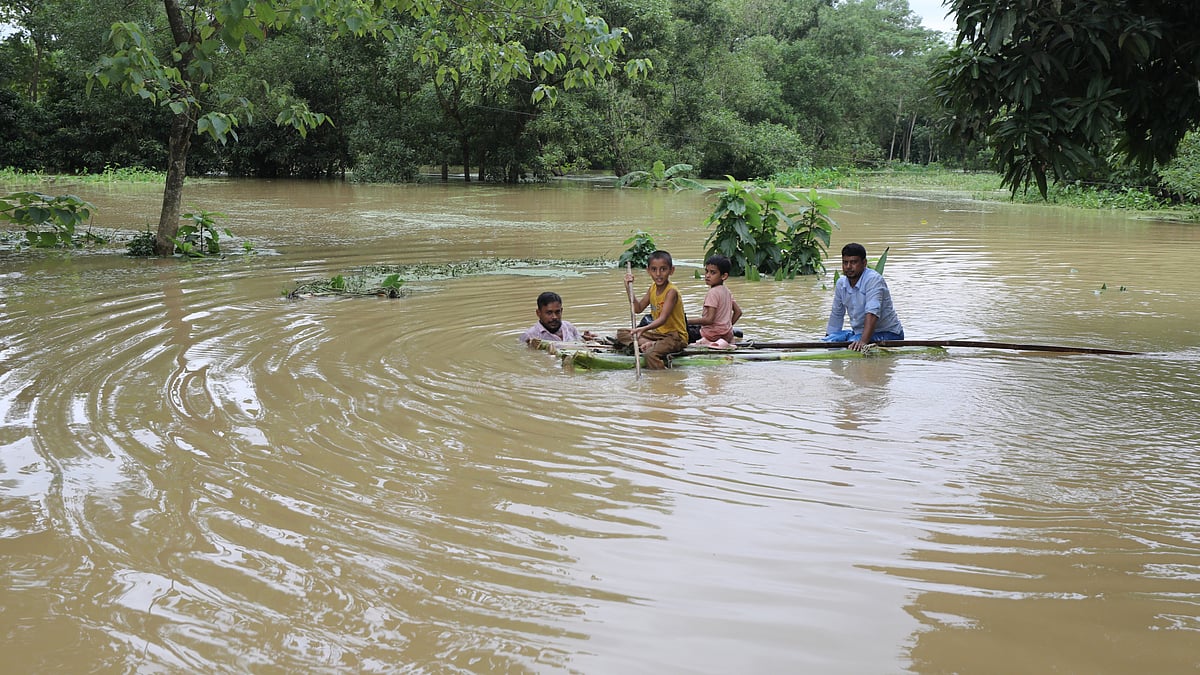 কলাগাছের ভেলায় করে পরিবারের শিশুদের নিরাপদ আশ্রয়ে নিয়ে যাচ্ছেন এক ব্যক্তি।