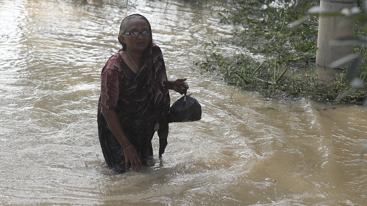 ত্রাণ সংগ্রহ করে বাড়ির দিকে যাচ্ছেন এক নারী।
