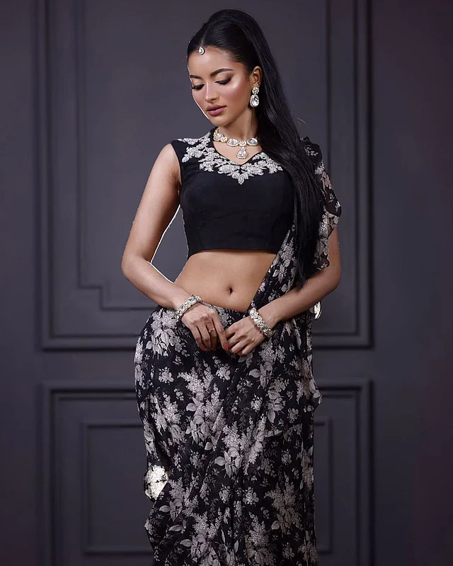 সাদা-কালো নেটের ফ্লোরাল শাড়ির আবেদনময় ড্রেপিং দেখা যাচ্ছে তুষির লুকে। শাড়ির পাড়ে রয়েছে একই ফেব্রিকের ফ্রিল দেওয়া নকশা, যা পোশাকটিকে আরও আকর্ষণীয় করে তুলেছে। নেকলাইন বরাবর কাজ করা ব্লাউজটিও  নজর কাড়ছে। 