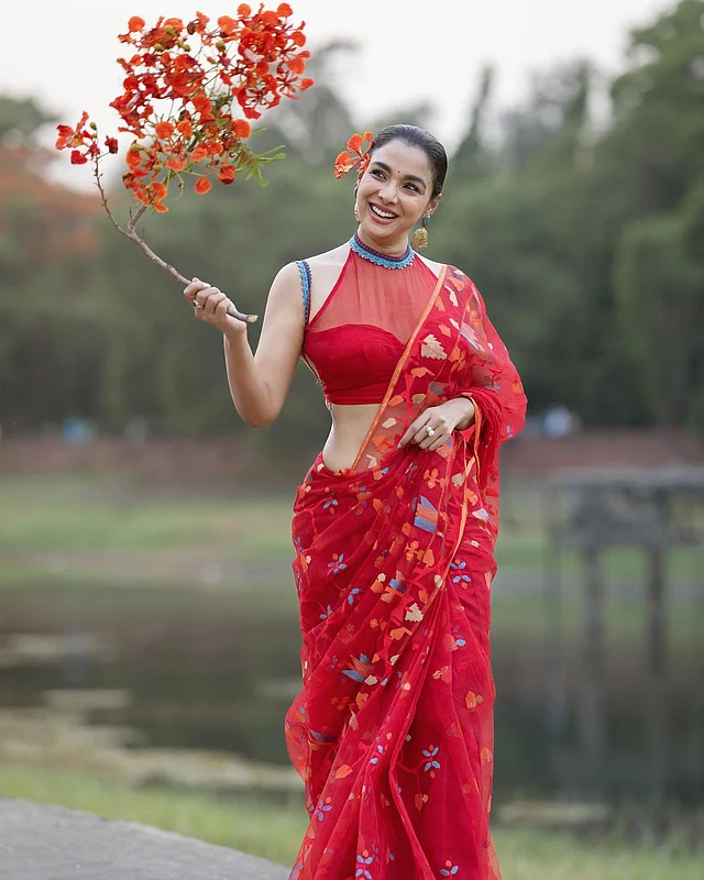কৃষ্ণচূড়ার থিমে রুনা খানের চোখধাঁধানো লুক। লাল জামদানিতে কমলা, সাদা, নীল ও লাল রঙের বুননে কারুকাজ করা। আলাদা করে বলতে হয় হল্টারনেক শিয়ার ফেব্রিকসের টকটকে লাল ব্লাউজটির কথা।