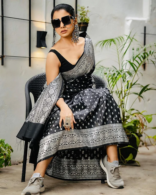 সাদা কালো-এর এই শাড়ির সাজকে অন্য মাত্রায় নিয়ে গেছে রুনা খানের বডি ল্যাঙ্গুয়েজ, স্নিকার্স, রোদচশমা আর চোখে পড়ার মতো ঝোলানো অক্সিডাইজড দুল। । 