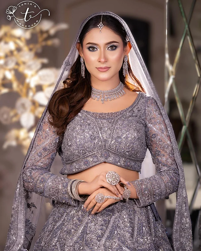 চিরাচরিত লাল কিংবা মেরুন নয়, ভিন্ন আমেজের প্লাটিনাম পার্পেল রঙের ফুলস্লিভ লেহেঙ্গা পরেছেন জনপ্রিয় অভিনেত্রী মেহজাবীন চৌধুরী। পুরো পোশাকেই রয়েছে সিকুইন, জারদৌসি আর পুঁতির নকশা করা ফ্লোরাল মোটিফের নিখুঁত কাজ। অভিনেত্রীর চোখের সাজে প্রাধান্য পেয়েছে কাজল আর পোশাকের রঙের আইশ্যাডো। ঠোঁটে শোভা পাচ্ছে ন্যুড পিঙ্ক ধাঁচের লিপস্টিক। এ ছাড়া ব্লাশঅন আর হাইলাইটার সাজকে দিয়েছে জমকালো ভাব। পোশাকের রঙের সঙ্গে মিলিয়ে বেছে নিয়েছেন নেকপিস, দুল, টিকলি, রতনচুর আর চুড়ি।
