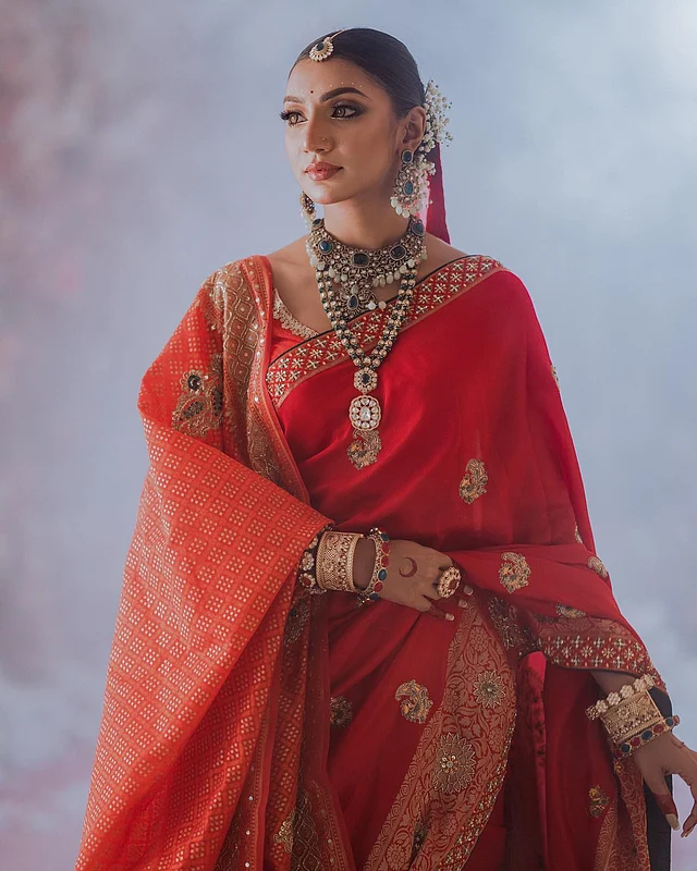 লাল শাড়ির আবেদন চিরন্তন। সঙ্গে মানানসই লাল ওড়না একপাশে স্টাইল করে নিয়েছেন অভিনেত্রী ও মডেল সুনেরাহ বিনতে কামাল। ট্রেন্ডি কুন্দন ও পাথরের ভারী গয়না এবং সেমিন্যুড মেকআপে সেজেছেন তিনি। স্লিক বানে শোভা বাড়িয়েছে জিপসি ফুল আর লাল ওড়না।