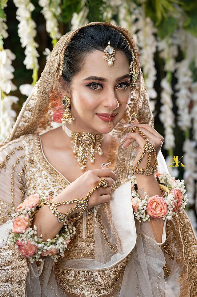 টিকলি, রতনচূড়সহ নজরকাড়া গয়নাগুলো রয়েল রুবিজ-এর। চোকার আর দুল খুব বড় পরেন নি এখানে বুবুলী। কুন্দন, সবুজ পাথর ও মুক্তার ব্যবহার দেখা যাচ্ছে গয়নায়। নজর কাড়ছে টানা নথ