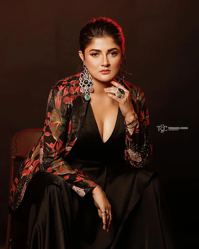 স্যাটিনের ডিপ ভি নেক প্যান্ট স্যুটের সঙ্গে ফুলেল জ্যাকেটের লেয়ারিং দেখা যাচ্ছে এই লুক। সঙ্গে শ্রাবন্তী পরেছেন লম্বা ঝোলানো দুল