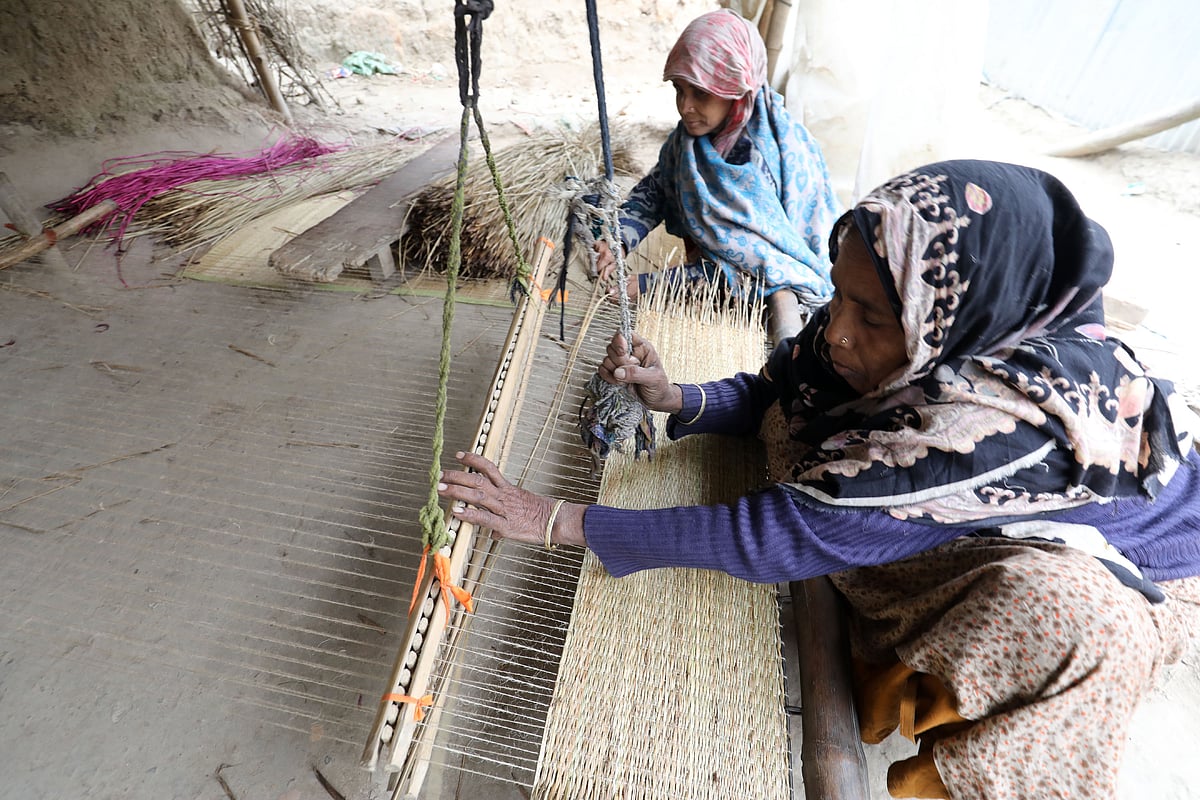 বাড়ির উঠানে বসে পাটি বানাচ্ছেন দুই নারী