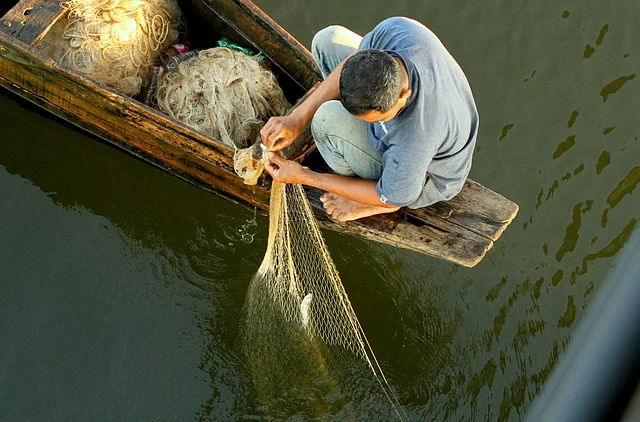 হ্রদে আগের দিন সন্ধ্যায় ফেলা জাল সকালে তুলে আনছেন এক মৎস্যশিকারি। ধরা পড়েছে লুন্ডু মাছ। খেপ্পোপাড়া এলাকা 