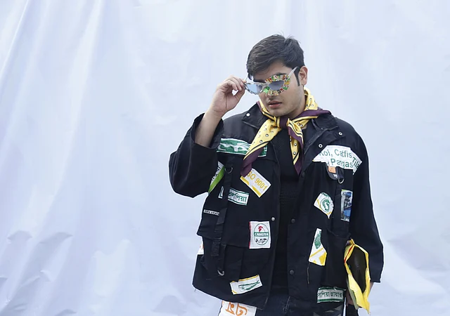 প্লেফুল প্যাচ জ্যাকেট আর কাঁচের টুকরা ও চিপসের প্যাকেট দিয়ে নকশা করা চশমা পরেছেন এই ফ্যাশন সচেতন তরুণ। দুটোই নিজের ডিজাইন করা 