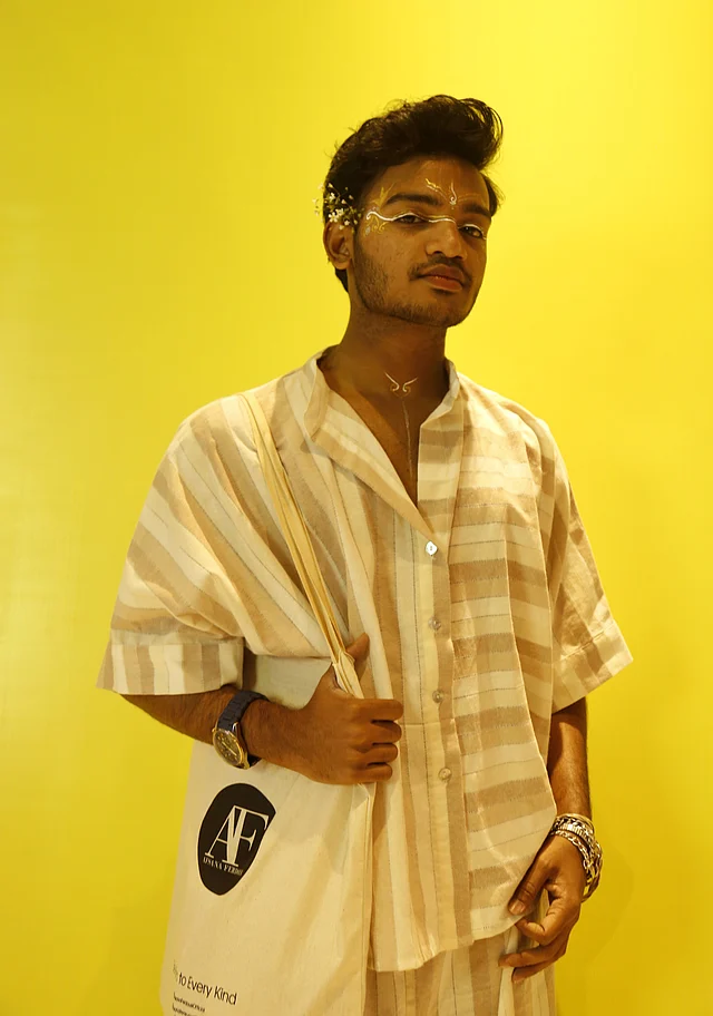 স্ট্রাইপড পাজামা শার্ট আর বটমে ফ্রেমবন্দি হয়েছেন এই তরুণ। নজড় কাড়ছে ফেসপেইন্ট আর কানে গোঁজা ফুল 