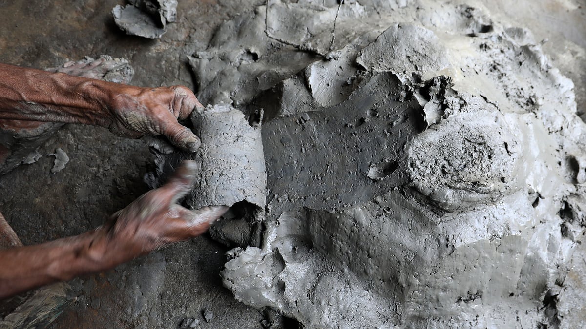 হাঁড়ি তৈরির জন্য নিপুণ হাতে মাটি ছেনে নিচ্ছেন শচিন পাল।