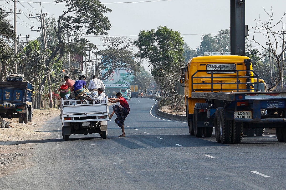  মহাসড়কের মাঝে পিকআপ ভ্যান থামিয়ে তোলা হচ্ছে লোক।