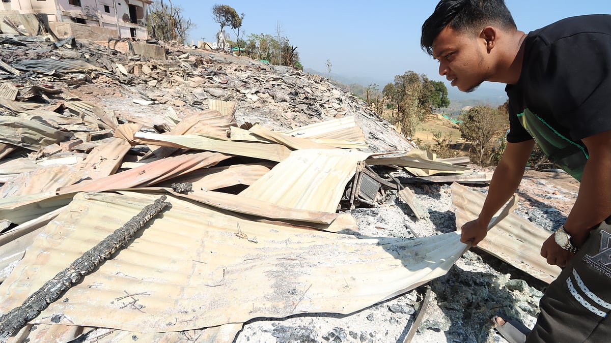 পুড়ে যাওয়া টিনগুলো পরখ করে দেখছেন কামরুল হাসান, যদি কাজে লাগানো যায়। এখানে তাঁর ছিল চার কক্ষের মাচাং বিলাস রিসোর্ট এবং একটি রেস্টুরেন্ট পেদা টিং টিং। আগুনে পুড়ে এখন কিছুই নেই।