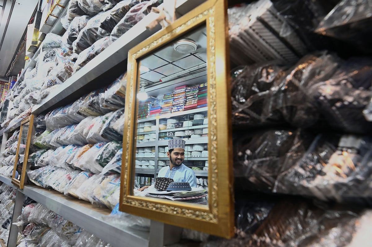 টুপির দোকানে টুপি বিক্রির জন্য বসে আছেন বিক্রেতা 