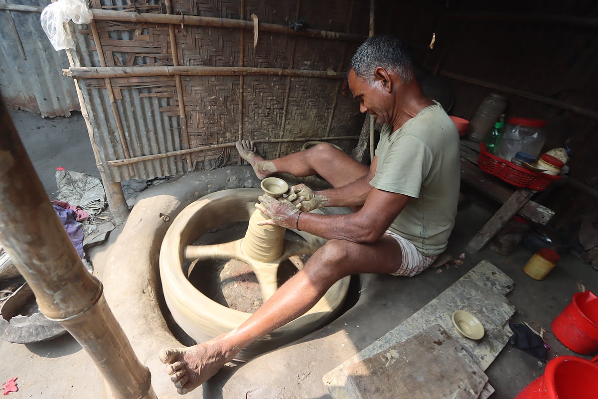 চাক ঘুরিয়ে মাটি দিয়ে খেলনা তৈরি করছেন কুমার 