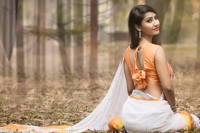 স্লিভলেস স্টেটমেন্ট ব্লাউজের পেছনে স্ট্রিং আর বো ডিটেইলস দেওয়া। সঙ্গে ফারিন পরেছেন সাদা সুতির শাড়ি