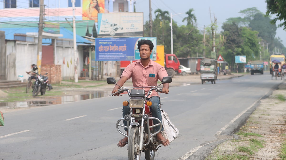  হেলমেট ছাড়াই মোটরসাইকেল চালিয়ে যাচ্ছেন একজন