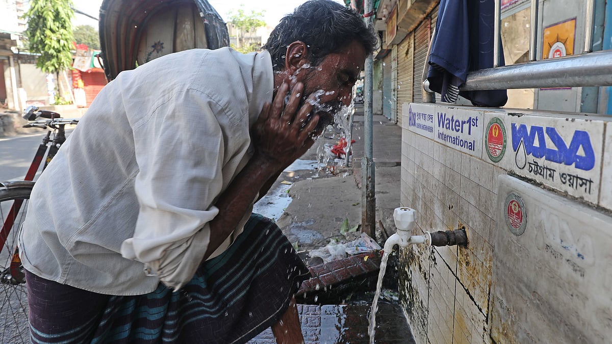 গরমে স্বস্তি পেতে চোখেমুখে পানি দিচ্ছেন এক রিকশাচালক