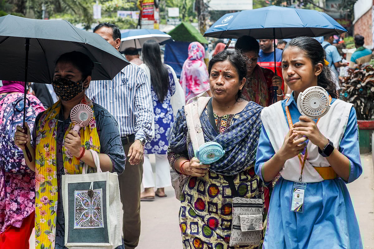 মাথায় ছাতা আর ফ্যান হাতে স্কুল থেকে ফিরছেন শিক্ষার্থী ও অভিভাবকেরা